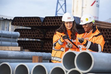 Two people looking at a table on a construction site 