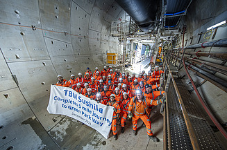 Gathering of people in a tunnel holding a sign saying 'TBM Sushila Completes 5 Mile Journey to Green Park Way'