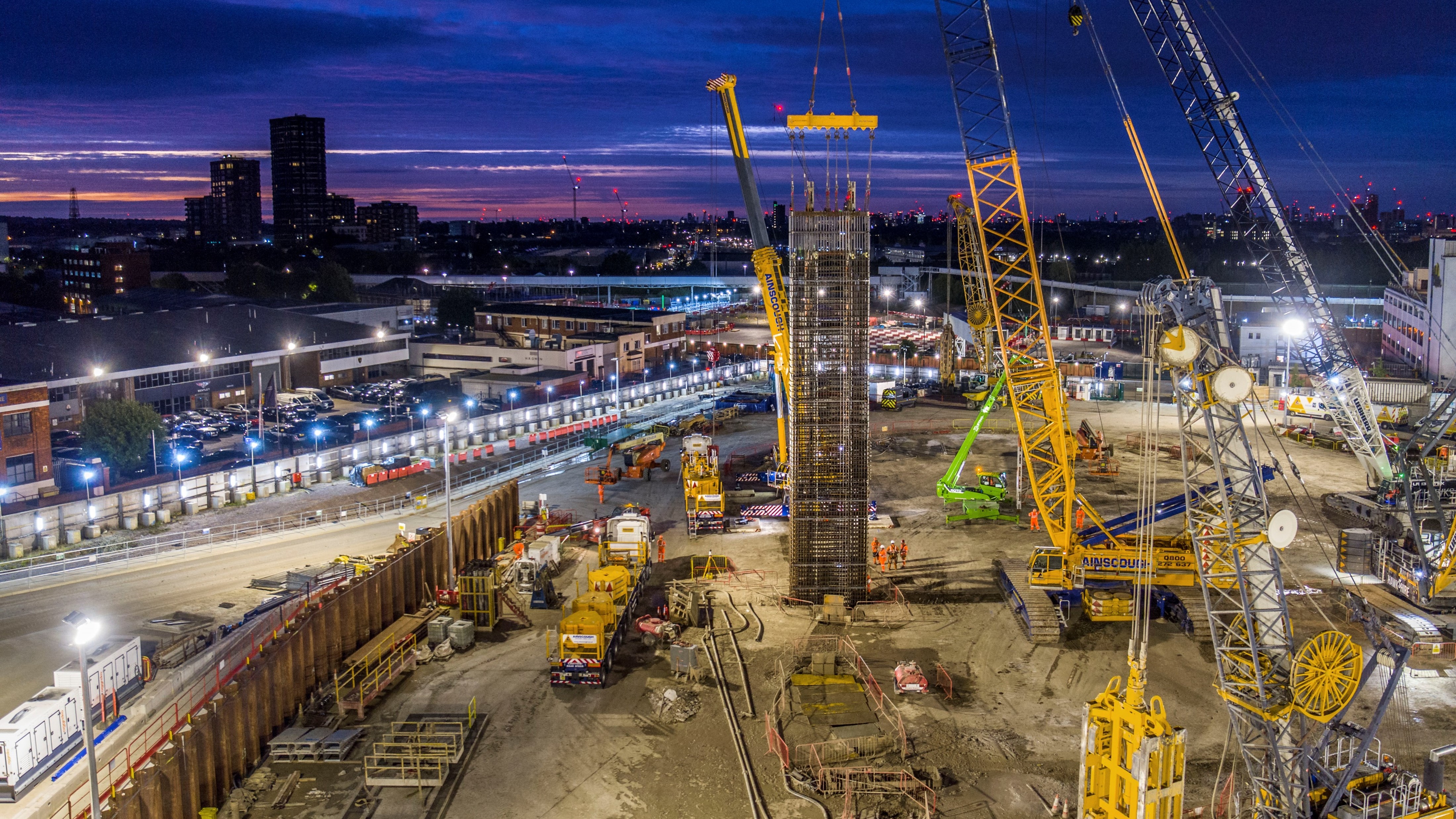 Aerial image of diaphragm walling being lowered into the ground with the London skyline in the background