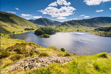 View of Haweswater with green hills and blue skies