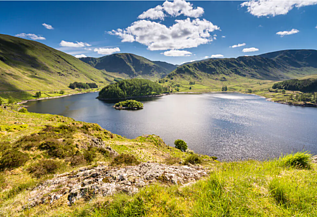View of Haweswater with green hills and blue skies