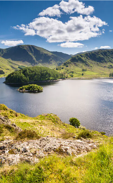 View of Haweswater with green hills and blue skies