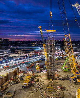 Ground engineering construction site in the UK with cranes installing deep foundations at dusk, illustrating STRABAG UK’s acquisition of Van Elle to strengthen geotechnical and civil engineering capabilities