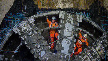 Two men inside the front cutterhead of the tunnel boring machine