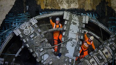 Two men inside the front cutterhead of the tunnel boring machine