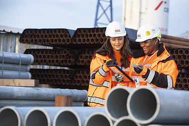 Two people looking at a table on a construction site 