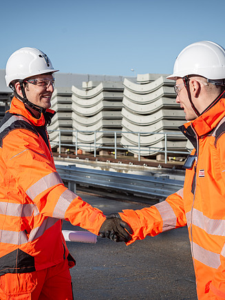 Two people shaking hands on a construction site